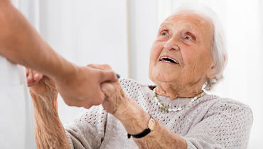 Senior_Patient_Holding_Hands_Of_Female_Doctor