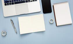 flat-lay-desk-arrangement-with-empty-notepad-blue-